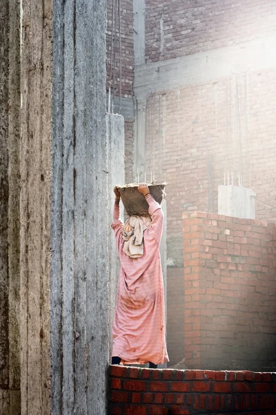 Женщина-строитель несёт на голове обломки. — стоковое фото