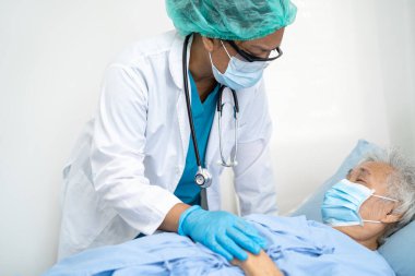 Doktor, hastanede güvenlik enfeksiyonunu korumak ve Covid19 Coronavirus 'u öldürmek için maske takan yaşlı ve yaşlı bir kadına yardım ediyor..