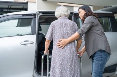 Yaşlı ve yaşlı kadın hastaya yardım ve destek ol. Walker 'la birlikte yürü. Arabasına bin, sağlıklı, güçlü tıbbi konsept..