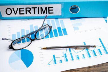 Fazla mesai. Binder veri finansmanı ofiste grafik analizi ile iş raporlama.