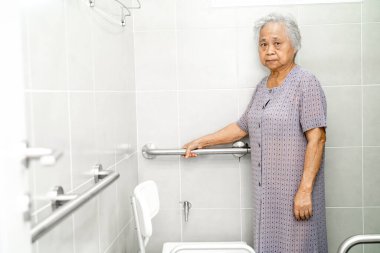 Asyalı yaşlı yaşlı kadın hasta, hemşire hastanesi koğuşunda tuvalet temizliği yapıyor. Sağlıklı güçlü tıbbi konsept..