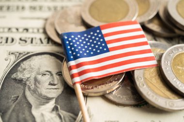 Dolar banknotları üzerinde Amerikan bayrağı olan bozuk para yığını.