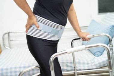 Ortopedik bel kemiği için sırt ağrısı destek kemeri takan Asyalı bir hasta..