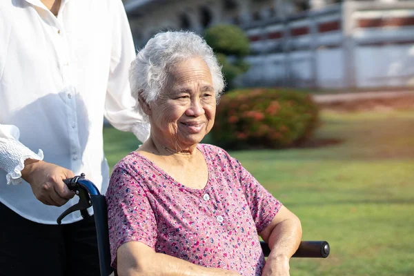 护理员帮助和照顾亚洲老年老年妇女病人坐在轮椅上 健康有力的医疗理念 — 图库照片