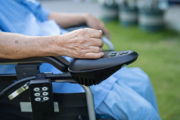 老人ホーム病棟で遠隔操作で電気自動車に乗っているアジアの高齢女性高齢者の女性 健康的な強い医療の概念 — ストック写真