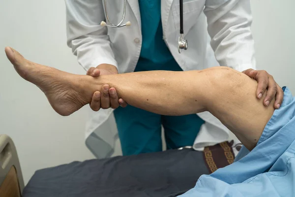 Asiatischer Arzt Physiotherapeut Untersucht Massiert Und Behandelt Knie Und Bein — Stockfoto