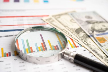 Grafik kağıdında büyüteç ve Amerikan doları banknotları. Mali kalkınma, Bankacılık Hesabı, İstatistikler, Yatırım Analitik Araştırma Veri Ekonomisi.