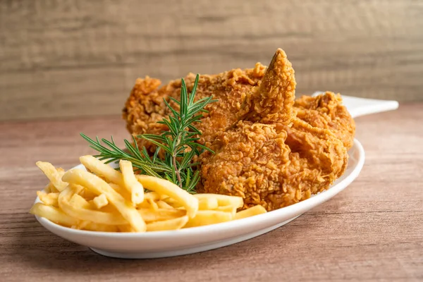 Fried chicken and potato chip with rosemary leaf, Junk food high calorie served on white plate