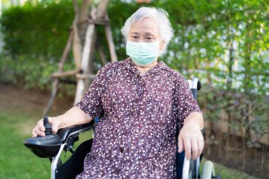 Uzaktan kumandalı ve güvenlik enfeksiyonu Covid 19 Coronavirus 'u korumak için maske takan yaşlı ve yaşlı bir kadın..