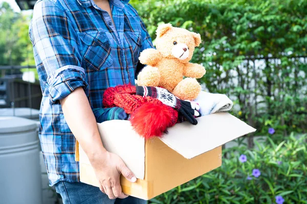 Κρατώντας Κουτί Δωρεά Ενδυμάτων Μεταχειρισμένα Ρούχα Και Κούκλα Στο Σπίτι — Φωτογραφία Αρχείου