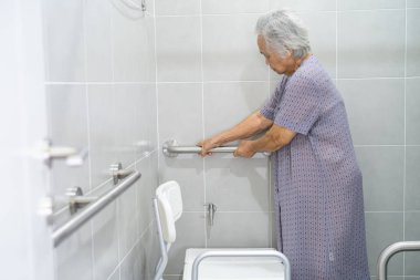 Asyalı yaşlı yaşlı kadın hasta, hemşire hastanesi koğuşunda tuvalet temizliği yapıyor. Sağlıklı güçlü tıbbi konsept..