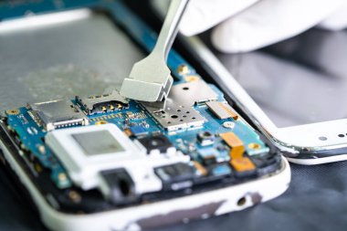 Akıllı telefonun içindeki Entegre Devre 'de tamirat teknisyeni. veri kavramı, donanım, teknoloji.
