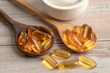 Balık yağı Omega 3 kapsülleri EPA ve DHA vitaminleri ahşap arka planda izole edilmiş..