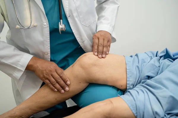 Asiatischer Arzt Physiotherapeut Untersucht Massiert Und Behandelt Knie Und Bein — Stockfoto