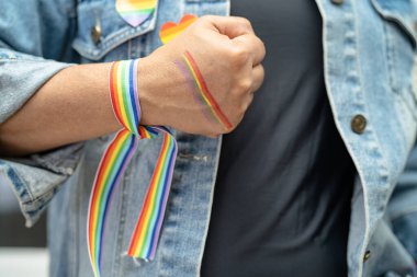 Gökkuşağı bilekliği takan Asyalı kadın, LGBT onur ayının sembolü Haziran sosyal ortamında gey, lezbiyen, biseksüel, transseksüel, insan hakları.