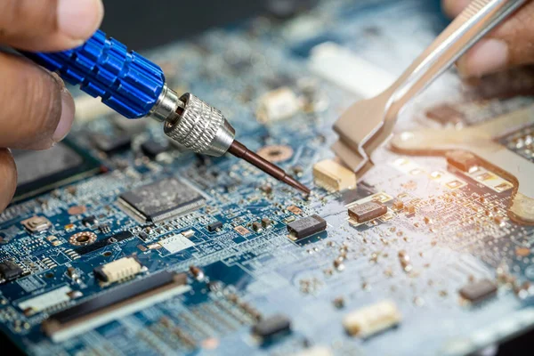 Levye kullanarak baskılı PCB 'nin içinde tamirat yapan teknisyen. Bütünleşik devre. Veri, donanım, teknisyen ve teknoloji kavramı.