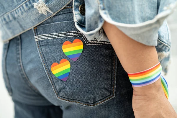 亚洲女子佩戴彩虹旗腕带 象征男女同性恋 双性恋 变性者自豪月 每年六月庆祝男女同性恋 双性恋 变性者 人权社会日 — 图库照片