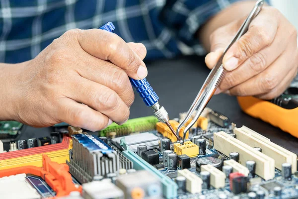 Technician repairing inside of mobile phone by soldering iron. Integrated Circuit. the concept of data, hardware, technology.