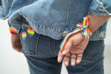 Gökkuşağı bilekliği takan Asyalı kadın, LGBT onur ayının sembolü Haziran sosyal ortamında gey, lezbiyen, biseksüel, transseksüel, insan hakları.