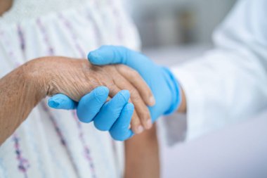 Doktor el ele tutuşuyor Asyalı yaşlı ya da yaşlı kadın hasta sevgi, ilgi, yardım, cesaret ve empati ile hemşire hastanesi koğuşunda sağlıklı güçlü tıbbi konsept