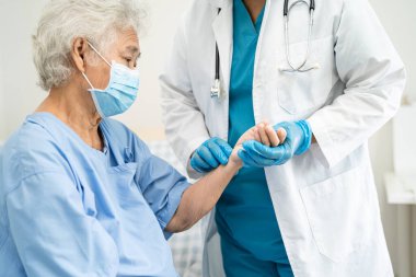 Doktor, hastanede güvenlik enfeksiyonu Covid-19 Coronavirus 'u korumak için maske takan yaşlı ve yaşlı kadın hastaları kontrol et..