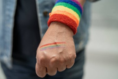 Gökkuşağı bilekliği takan Asyalı kadın, LGBT onur ayının sembolü Haziran sosyal ortamında gey, lezbiyen, biseksüel, transseksüel, insan hakları.