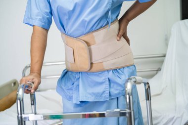Ortopedik bel kemiği için sırt ağrısı destek kemeri takan Asyalı bir hasta..
