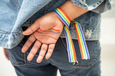 Gökkuşağı bilekliği takan Asyalı kadın, LGBT onur ayının sembolü Haziran sosyal ortamında gey, lezbiyen, biseksüel, transseksüel, insan hakları.