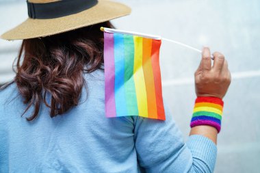 LGBT gurur ayının sembolü Asyalı kadın elinde gökkuşağı bayrağı, Haziran ayının geleneksel gay, lezbiyen, biseksüel, transseksüel, insan haklarını kutluyor.