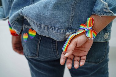 Gökkuşağı bilekliği takan Asyalı kadın, LGBT onur ayının sembolü Haziran sosyal ortamında gey, lezbiyen, biseksüel, transseksüel, insan hakları.