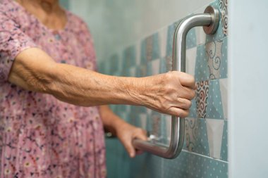 Asyalı yaşlı yaşlı kadın hasta, hemşire hastanesi koğuşunda tuvalet temizliği yapıyor. Sağlıklı güçlü tıbbi konsept..