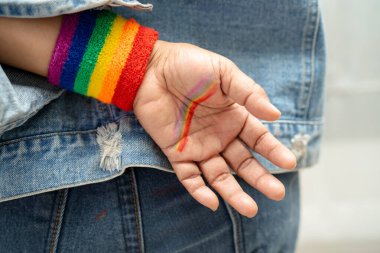 Gökkuşağı bilekliği takan Asyalı kadın, LGBT onur ayının sembolü Haziran sosyal ortamında gey, lezbiyen, biseksüel, transseksüel, insan hakları.
