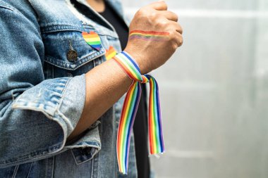 Gökkuşağı bilekliği takan Asyalı kadın, LGBT onur ayının sembolü Haziran sosyal ortamında gey, lezbiyen, biseksüel, transseksüel, insan hakları.