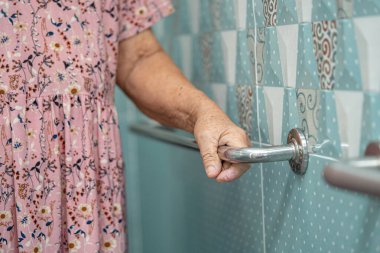 Asyalı yaşlı yaşlı kadın hasta, hemşire hastanesi koğuşunda tuvalet temizliği yapıyor. Sağlıklı güçlü tıbbi konsept..