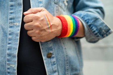 Gökkuşağı bilekliği takan Asyalı kadın, LGBT onur ayının sembolü Haziran sosyal ortamında gey, lezbiyen, biseksüel, transseksüel, insan hakları.