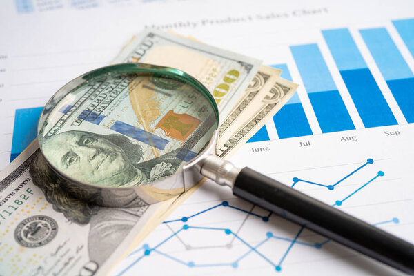 Magnifying glass with US dollar banknotes on charts graphs paper. Financial development, Banking Account, Statistics, Investment Analytic research data economy.