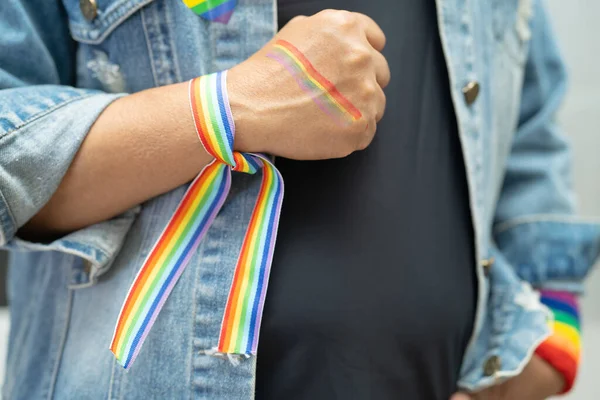 亚洲女子佩戴彩虹旗腕带 象征男女同性恋 双性恋 变性者自豪月 每年六月庆祝男女同性恋 双性恋 变性者 人权社会日 — 图库照片