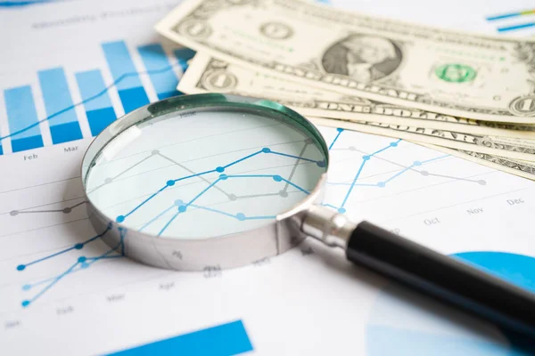 Magnifying glass with US dollar banknotes on charts graphs paper. Financial development, Banking Account, Statistics, Investment Analytic research data economy.