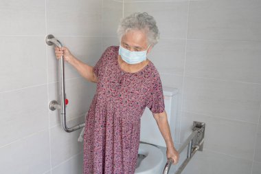 Asyalı yaşlı yaşlı kadın hasta, hemşire hastanesi koğuşunda tuvalet temizliği yapıyor. Sağlıklı güçlü tıbbi konsept..