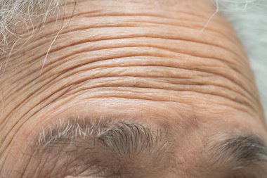 Asian elderly old woman face and eye with wrinkles, portrait closeup view.