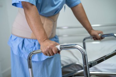 Ortopedik bel kemiği için sırt ağrısı destek kemeri takan Asyalı bir hasta..