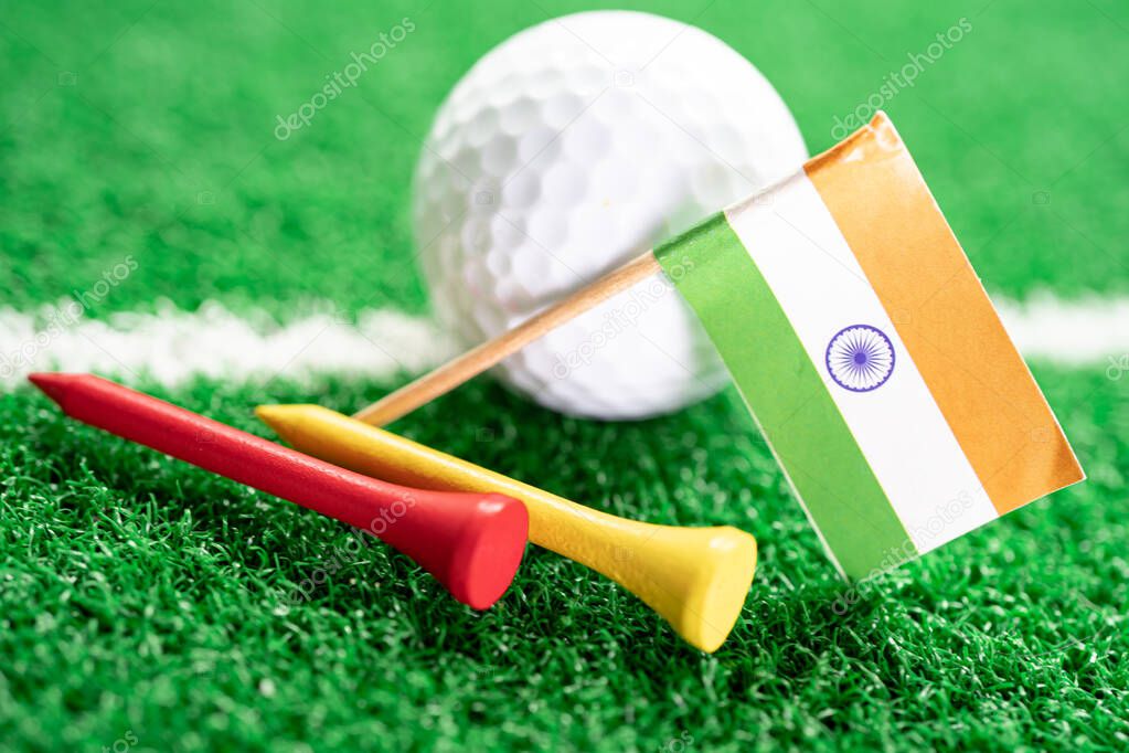 Golf ball with India flag and tee on green lawn or grass is most popular sport in the world.