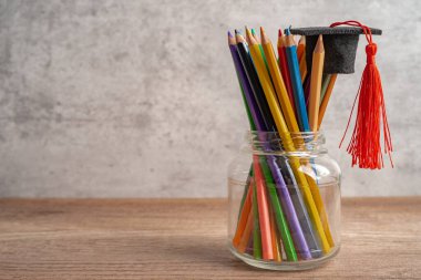 Fotokopi alanı olan renkli kalemli mezuniyet şapkası, üniversite eğitimi kavramı..