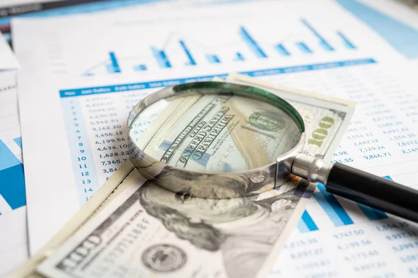 Magnifying glass with US dollar banknotes on charts graphs paper. Financial development, Banking Account, Statistics, Investment Analytic research data economy.