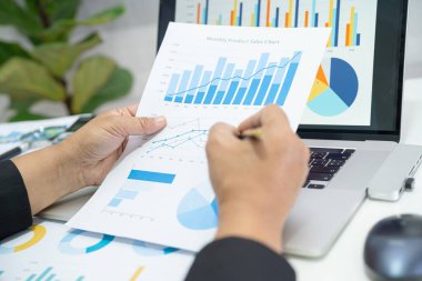 Modern ofis, finans ve iş konsepti grafikleriyle muhasebe projesini inceleyen Asyalı muhasebeci.