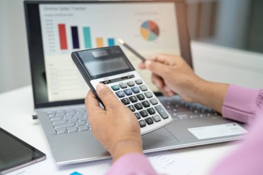 Modern ofis, finans ve iş konsepti grafikleriyle muhasebe projesini inceleyen Asyalı muhasebeci.