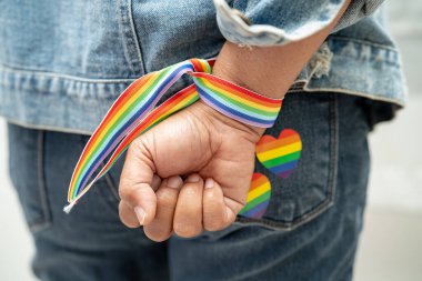 Gökkuşağı bilekliği takan Asyalı kadın, LGBT onur ayının sembolü Haziran sosyal ortamında gey, lezbiyen, biseksüel, transseksüel, insan hakları.