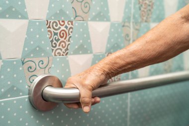 Asyalı yaşlı yaşlı kadın hasta, hemşire hastanesi koğuşunda tuvalet temizliği yapıyor. Sağlıklı güçlü tıbbi konsept..