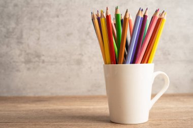 Colorful pencils in white cup with copy space, learning university education concept.