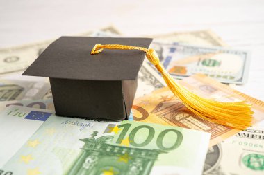 Graduation gap hat on US dollar and EURO banknotes money, Education study fee learning teach concept.
